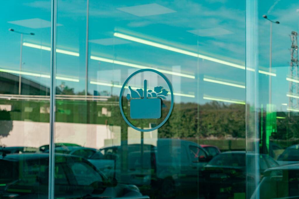 Reflejo de logo de Mercadona en puerta principal de Mercadona Parque Guadaíra